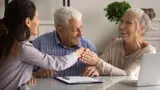 elderly couple with lawyer smiling