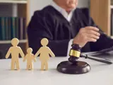 judge with gavel and wooden family figures