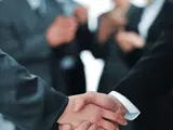 people shaking hands with blurred people in the background